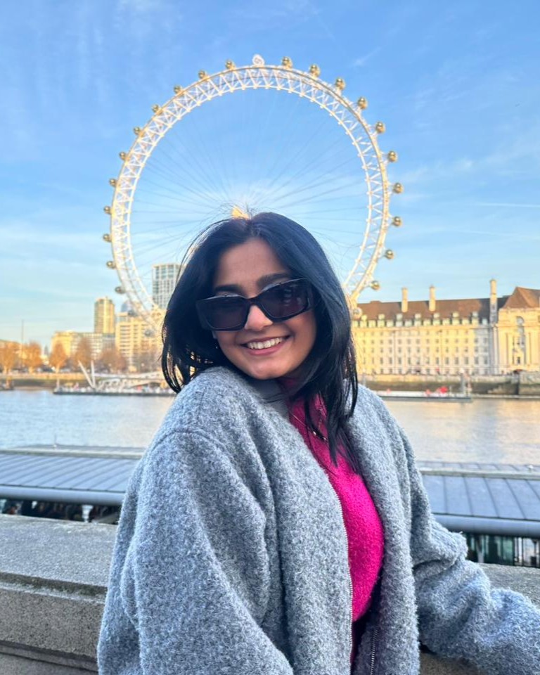 Saloni smiling outdoors in front of the London Eye